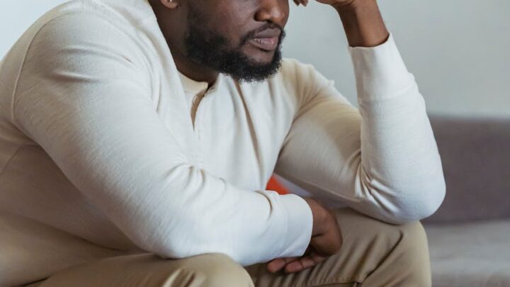 frustrate black man sitting near laptop and thinking